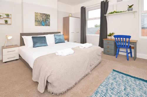 特伦特河畔斯托克Venture House by YourStays的一间卧室配有一张床和一张蓝色椅子