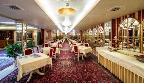 克拉根福波尔恰宫酒店的一间带桌椅和吊灯的餐厅