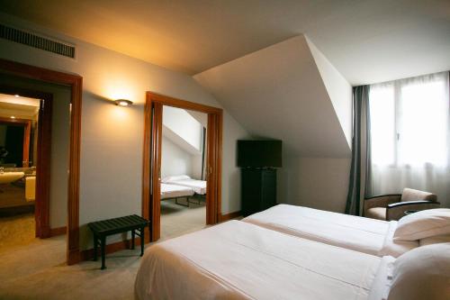 奥维多德城奥维多酒店的酒店客房,设有两张床和镜子