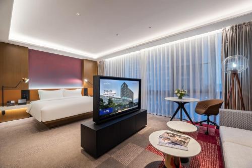 东莞东莞松山湖高新诺富特酒店的配有一张床和一台平面电视的酒店客房