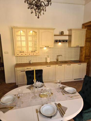 班斯卡 - 什佳夫尼察Apartmány Svätá Barborka的厨房配有带盘子和玻璃杯的桌子