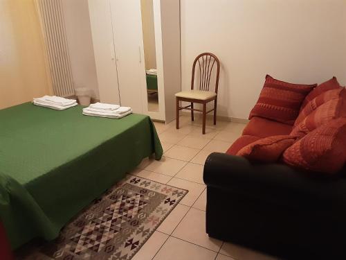 帕多瓦Locazione Menini - Camere zona stazione的配有床、沙发和椅子的房间