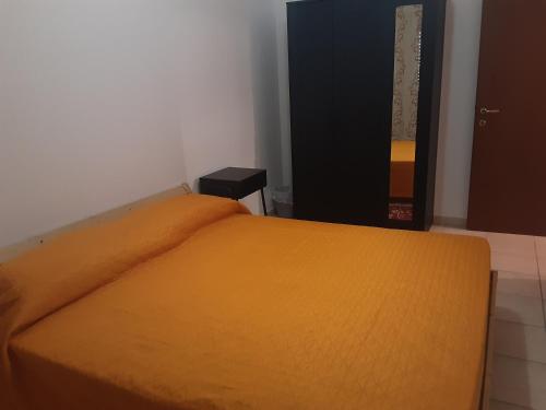 帕多瓦Locazione Menini - Camere zona stazione的一间卧室配有一张带橙色毯子的床