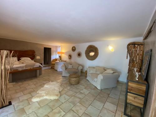 卡利昂Domaine De Sainte Annette的客厅配有2把白色椅子和1张床