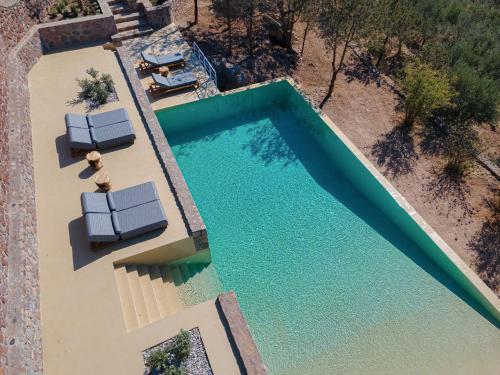 派尔季卡Aelia & Melitta Villas的享有带2张躺椅的游泳池的顶部景致