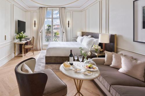 马德里Mandarin Oriental Ritz, Madrid的酒店客房配有床、沙发和桌子。