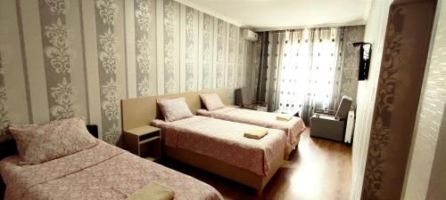 第比利斯Hotel VENUS的酒店客房设有两张床和窗户。