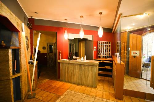 克利通诺河畔坎佩洛贝内德缇酒店的一间厨房,里面设有红色的墙壁和柜台