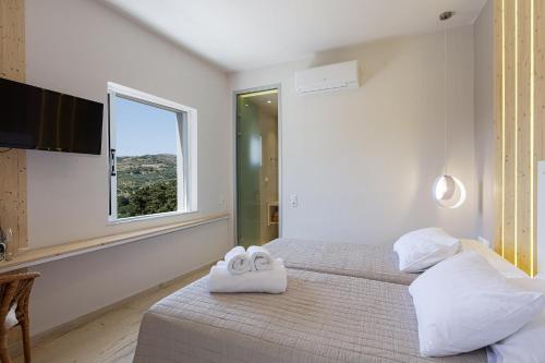 SpílionSpilGaia的白色卧室配有两张带毛巾的床