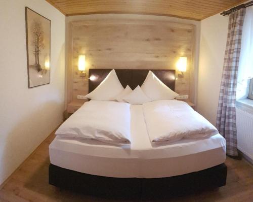 阿尔拉赫Kieslinger Hilde的卧室配有一张带白色床单和枕头的大床。