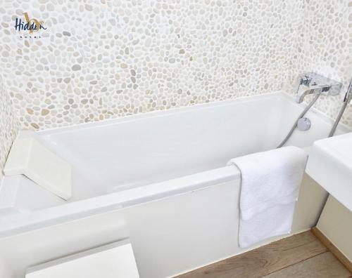 滨海卡约Hidden Bay Hotel的浴室设有位于水槽旁的白色浴缸。
