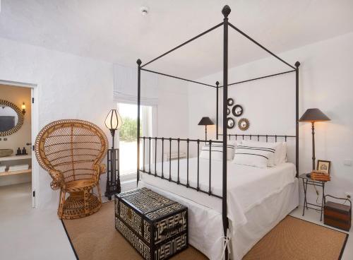 EstevaisRufino Quinta的一间卧室配有一张天蓬床和一把椅子
