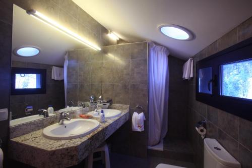 奥尔迪诺普拉德米纳斯旅游公寓酒店的浴室配有盥洗盆、浴缸和盥洗盆