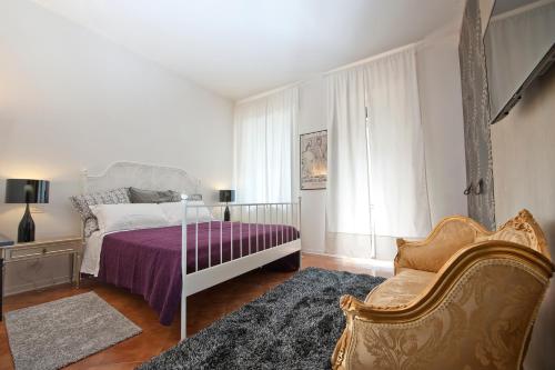 维罗纳维罗纳梅森酒店的一间卧室配有一张床、一张沙发和一把椅子
