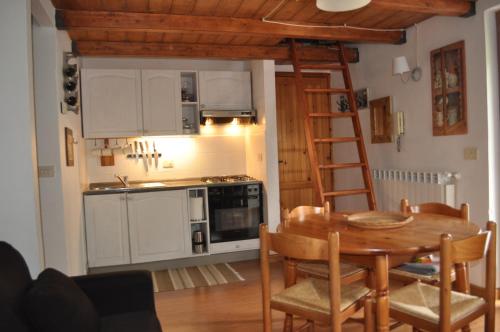 奥温多利Appartamento ad Ovindoli的厨房以及带桌子和梯子的用餐室