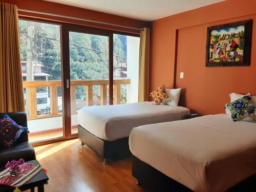 马丘比丘USGAR Machupicchu Boutique的酒店客房设有两张床和窗户。