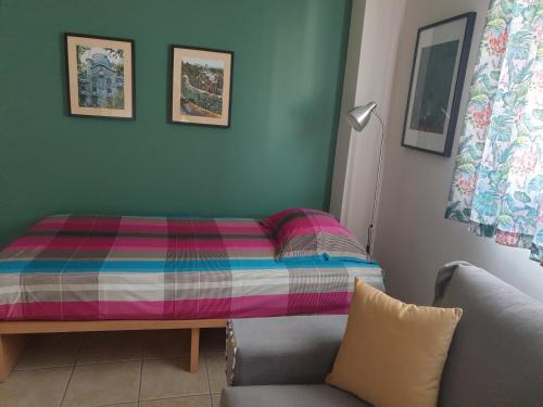 沃洛斯Comfortable apartment in the center of Volos very close to the port的一张位于配有沙发和椅子的房间的床铺