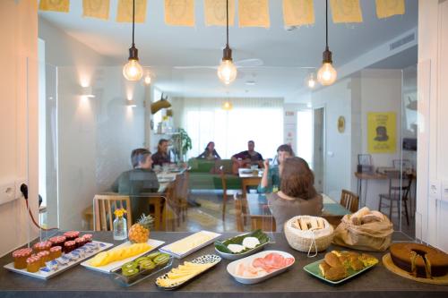 蓬塔德尔加达THE HOLY COW - Hostel & Suites的一群人坐在餐桌旁吃着食物