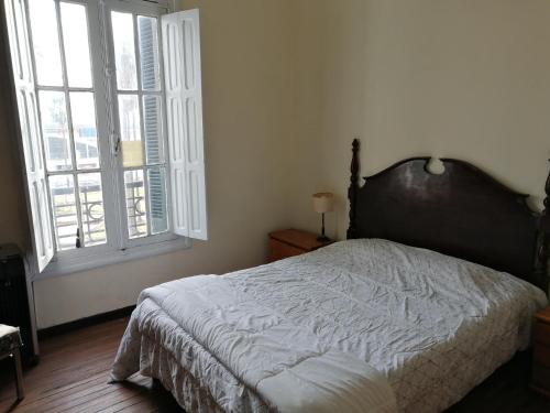 蒙得维的亚Apartamento en Edificio Palacio Colón的一间卧室设有一张床和一个大窗户