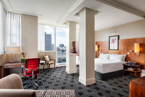 蒙特利尔蒙特利尔索菲特酒店的配有一张床和一张书桌的酒店客房