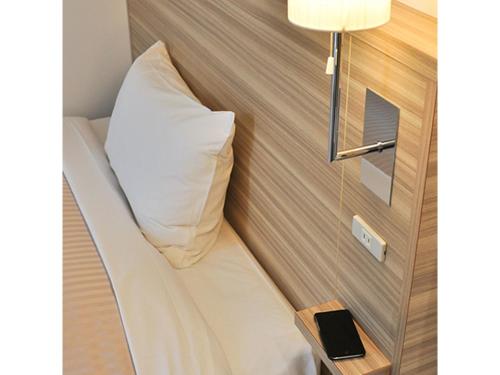 YabuPure Hotel - Vacation STAY 44185v的一个小房间里一张床铺,上面有枕头