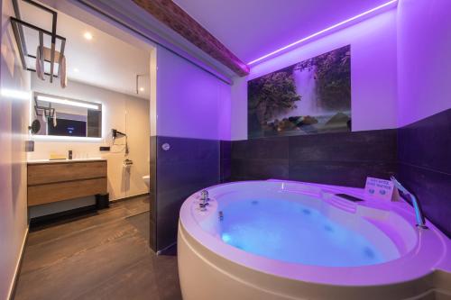 法尔肯堡Boutique Hotel Scheepers的浴室配有带紫色照明的大浴缸