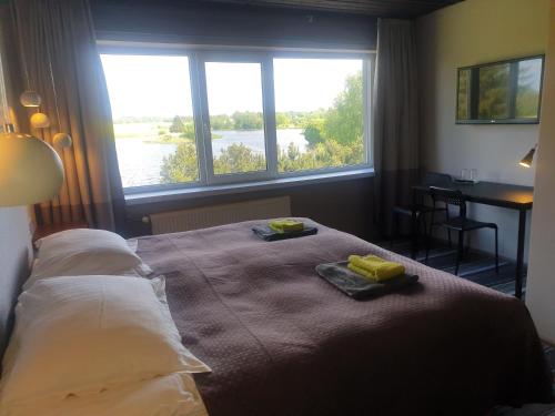 Ilmatsalu伊玛萨露汽车旅馆的一间卧室配有一张床,上面有两条毛巾