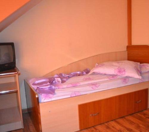 苏恰瓦Pensiune Restaurant Brândușa的一张带梳妆台的床和客房内的电视