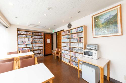 ŌwadaTabist Hotel Diana Yachiyodai的图书馆藏书架和微波炉