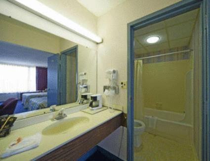 桑兹顿Express Airport Inn的一间带水槽和镜子的浴室