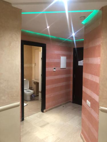 马拉喀什Appartements Marrakech Garden的客房设有带卫生间和绿灯的浴室。