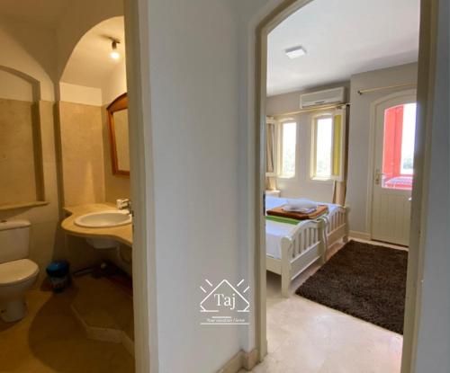 赫尔格达Taj Home, Amazing pool and lagoon view 2bedrooms apartment的一间带床、水槽和卫生间的浴室