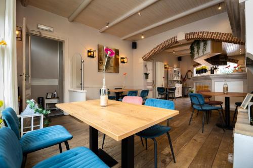 德哈恩De Zonnetuin的一间带木桌和蓝色椅子的用餐室