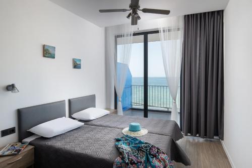 阿吉亚特拉萨Grand Dodo's Triada Seaview Studios的一间带两张床的卧室,享有海景