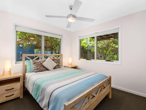 金斯克里福Casuarina Beach Shacks 10 with Pool的一间卧室设有一张床和两个窗户。