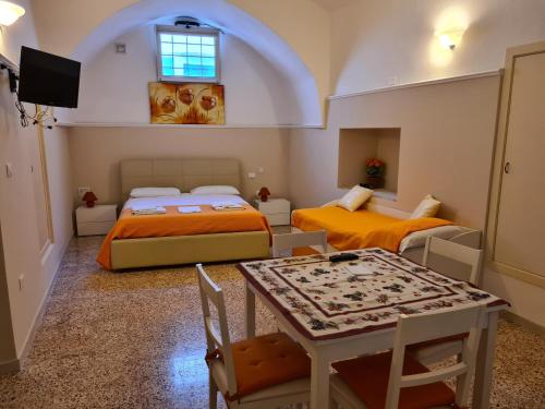 帕拉比塔B&B Il Ventaglio的小房间设有两张床和一张桌子