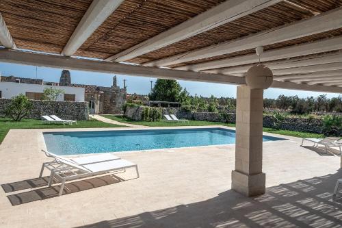 梅伦杜尼奥Masseria Berzario的一个带游泳池和凉亭的庭院