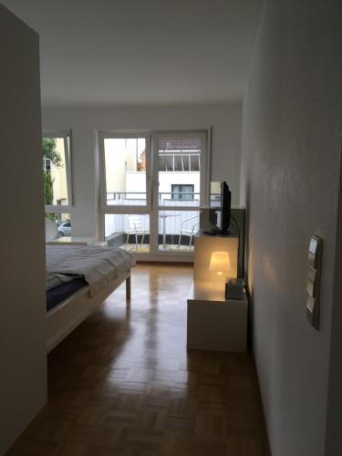 路德维希堡Ferienwohnung-Ludwigsburg-City的一间卧室配有一张床和一张桌子上的电视