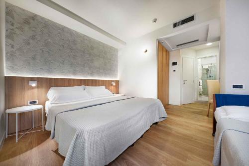 里乔内昂蒂布酒店的卧室配有一张白色大床