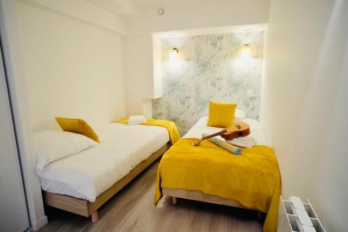 凯恩City Affaire : Hotel de Ville的小客房内的两张床,配有黄色床单
