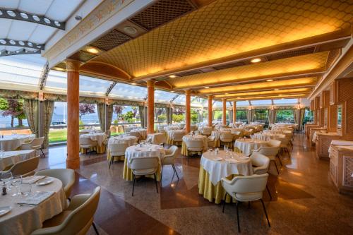斯特雷萨阿索托丽亚酒店的宴会厅配有白色的桌椅
