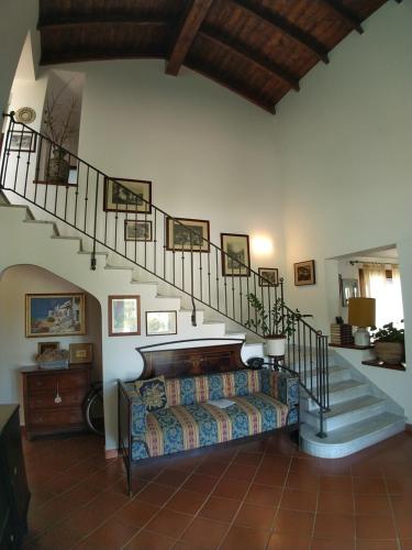 阿尔盖罗伊尔帕吉奥酒店的一间带楼梯和沙发的客厅