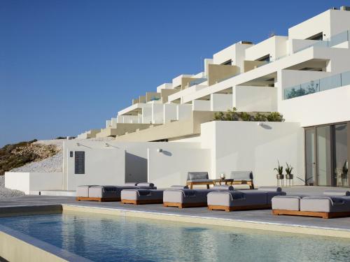 MytakasDomes White Coast Milos, Adults Only - Small Luxury Hotels of the World的一座别墅,在一座建筑前设有一个游泳池