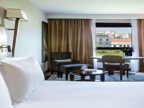 里斯本里斯本索菲特大饭店的酒店客房设有床和客厅。