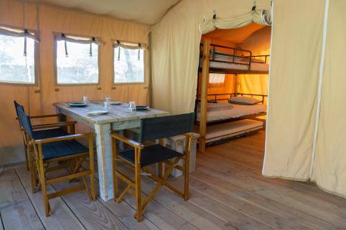PerarruaTiendas safari Chill-Outdoor的客房设有桌椅和一张双层床。