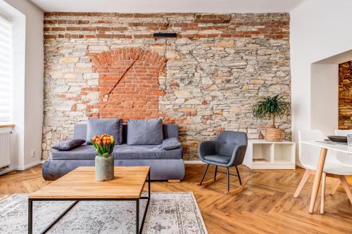 波杰布拉迪Design Pension Twenty 20的带沙发和砖墙的客厅