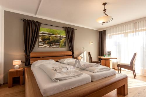 埃尔毛Hotel Hochfilzer的一间卧室配有一张带白色床单的大床