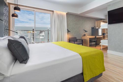 塞维利亚加泰罗尼亚吉拉达酒店的酒店客房设有一张床和一个大窗户