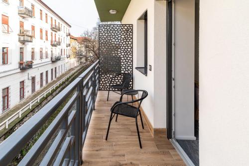 米什科尔茨Arany Apartman Miskolc的阳台配有两把椅子和栏杆