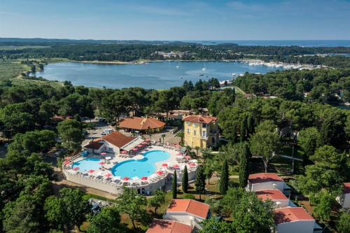 波雷奇Apartments Bellevue Plava Laguna的享有带游泳池和湖泊的度假村的空中景致